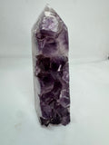 Amethyst crystal point on a white background