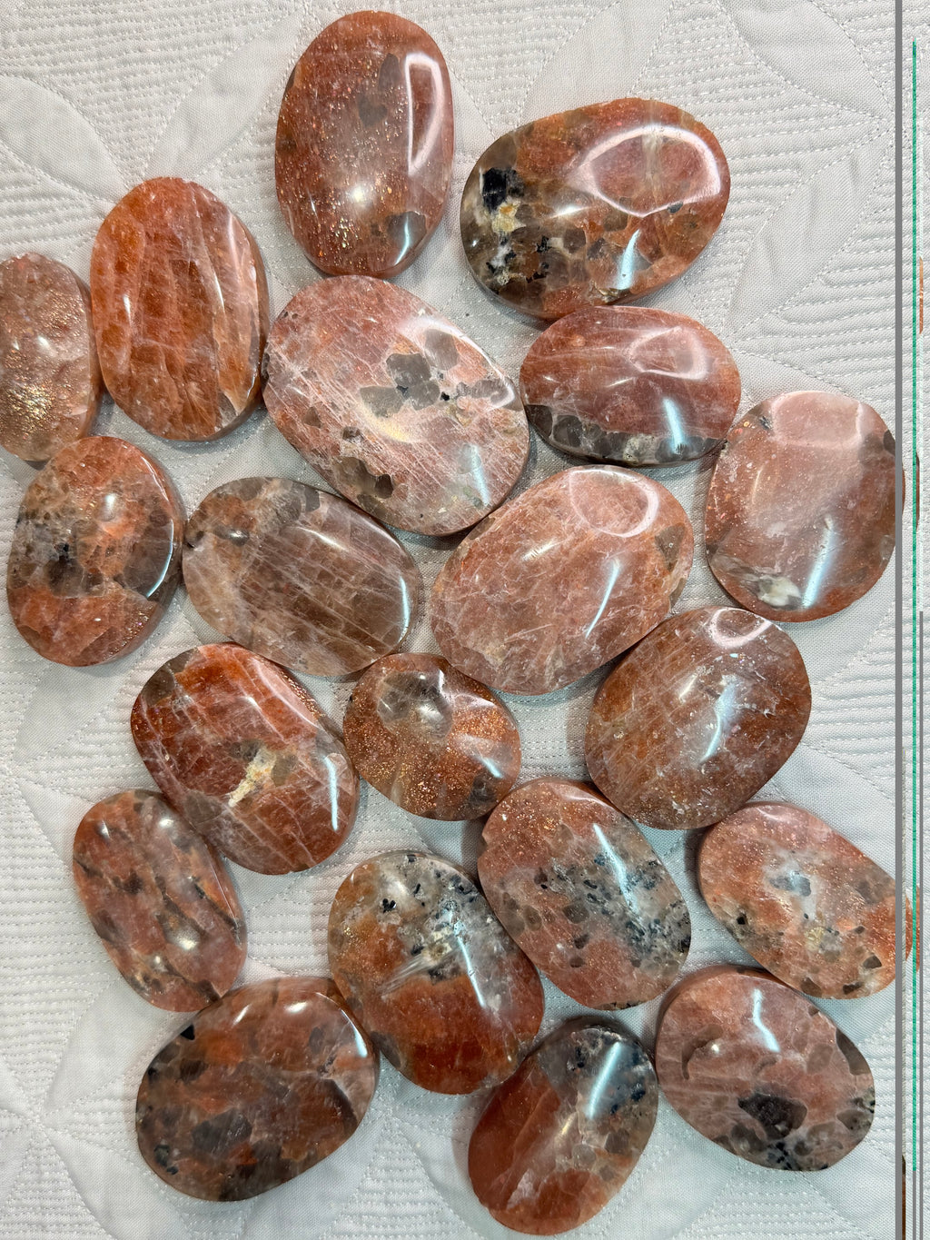 Collection of polished brown stones on a textured surface