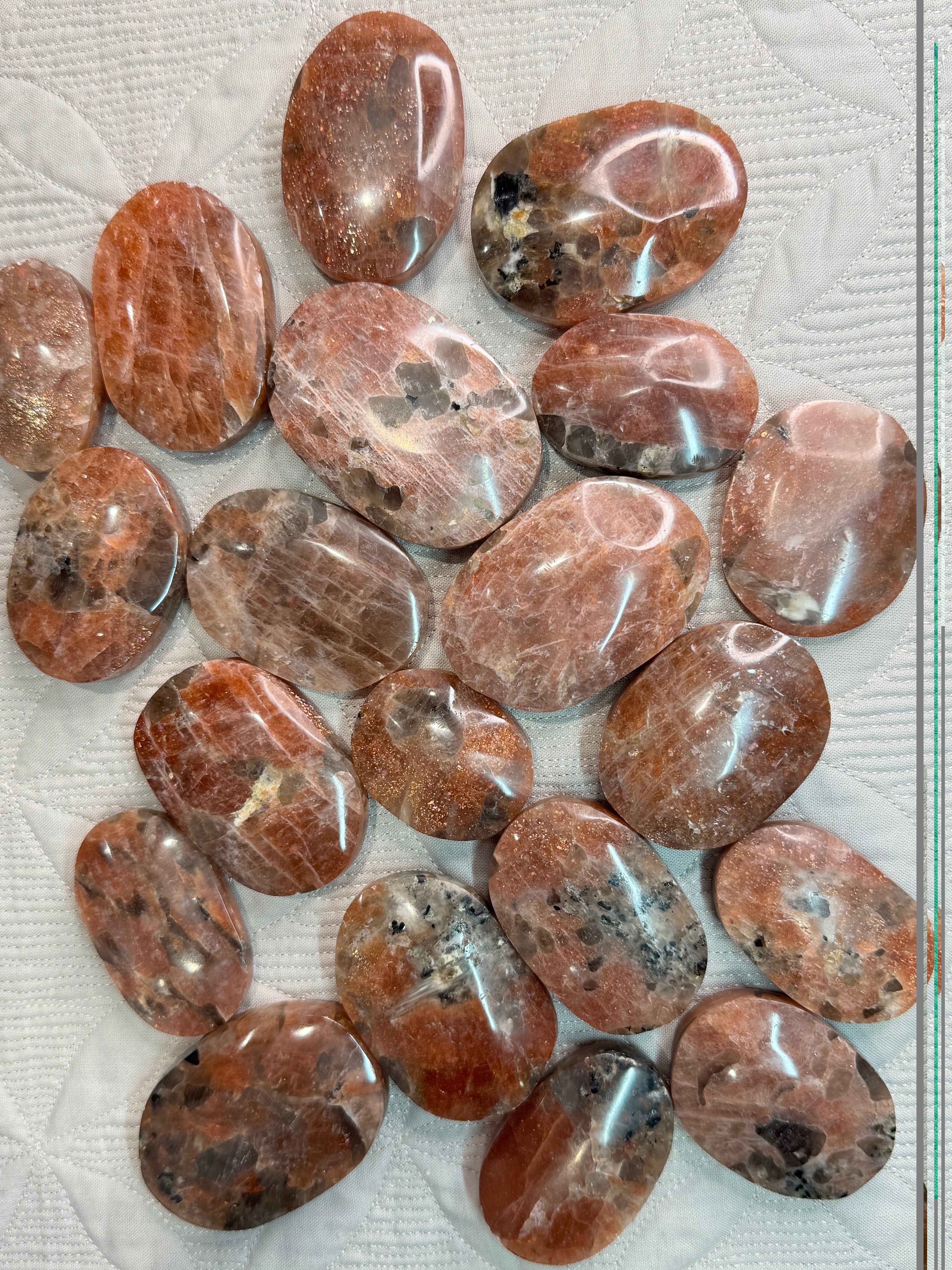 Collection of polished brown stones on a textured surface